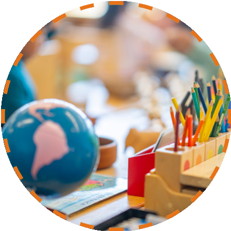 Group-1321316680.png (4) (1) A globe and some pencils on top of a desk.