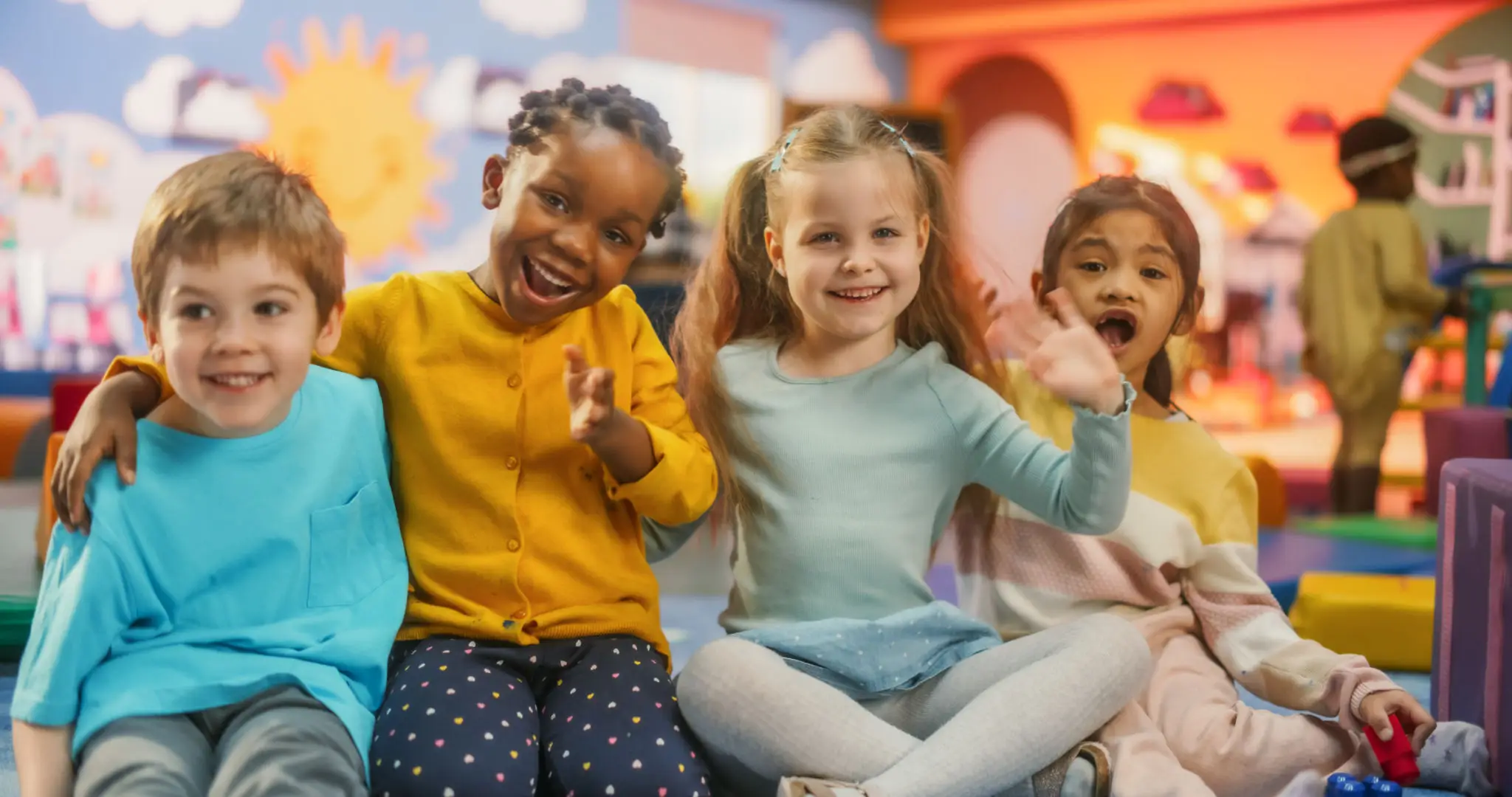 1a1ba385-aa1a-4600-9930-b1536c9ae74a Three children sitting in a row and smiling.